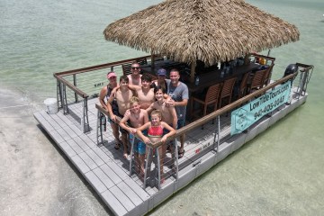 a group of people sitting on a dock next to a body of water