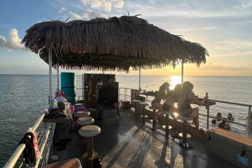 a group of people sitting next to a body of water