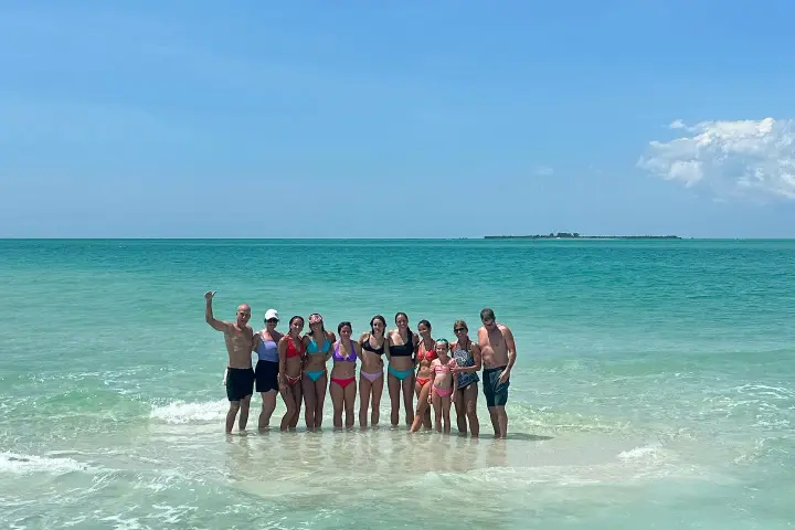 a group of people standing next to a body of water