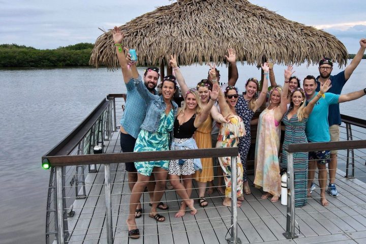 a group of people sitting on a bench next to a body of water