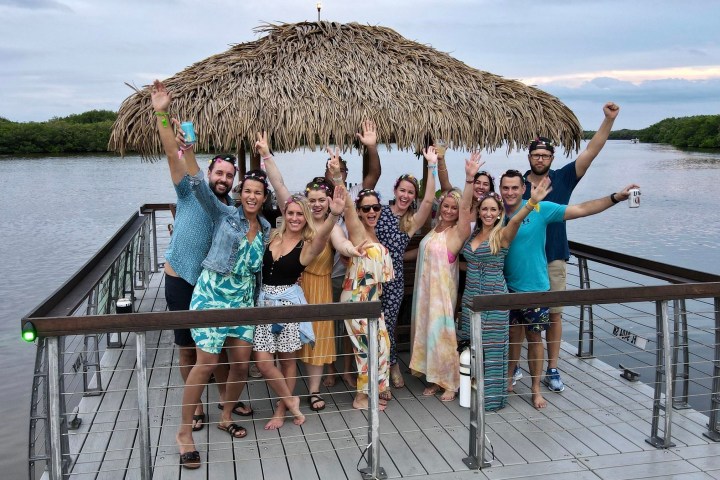 a group of people sitting on a bench next to a body of water